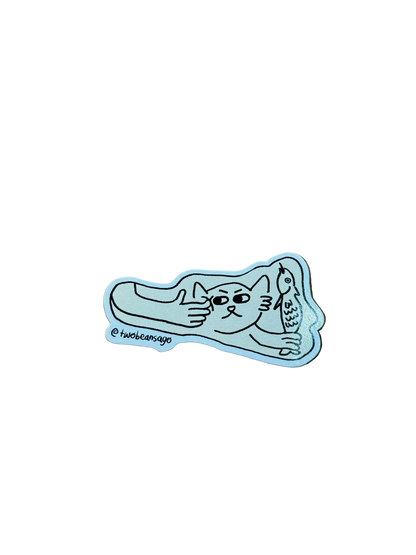 A die-cut sticker featuring a cat holding a fish and the cat is getting poked by a human finger.