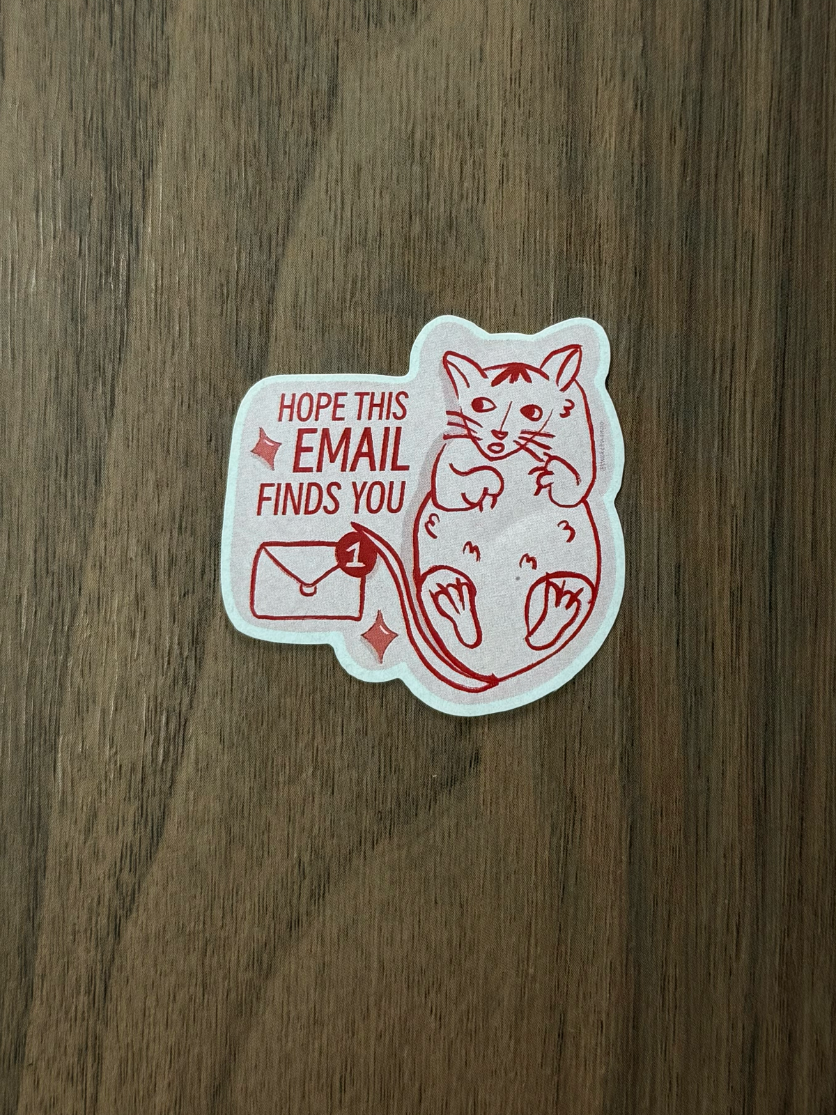 A die-cut sticker featuring a red line art cat and the text 'HOPE THIS EMAIL FINDS YOU' 