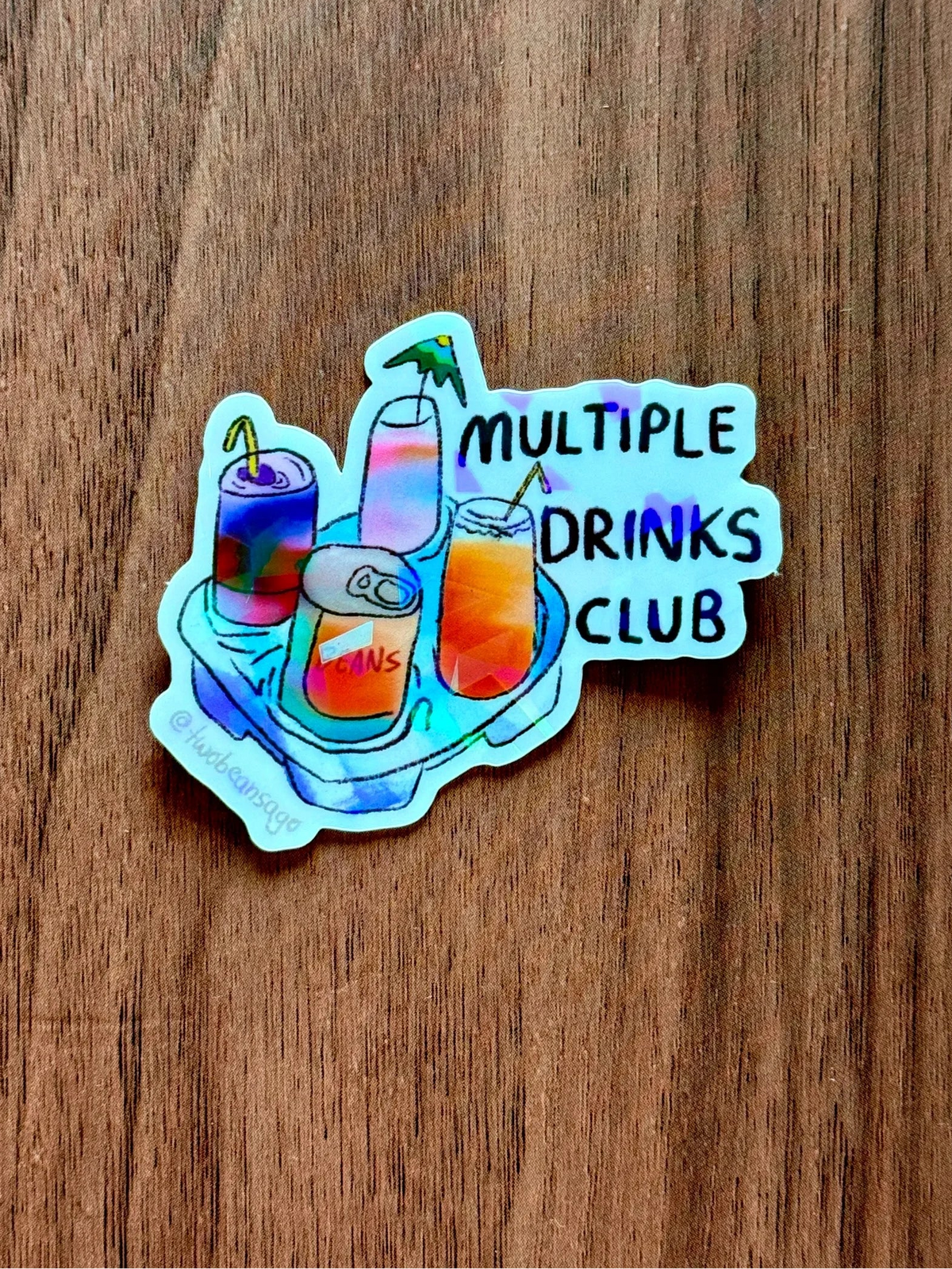 A die-cut sticker featuring an illustration of colorful drinks on a tray with the text 'MULTIPLE DRINKS CLUB' 