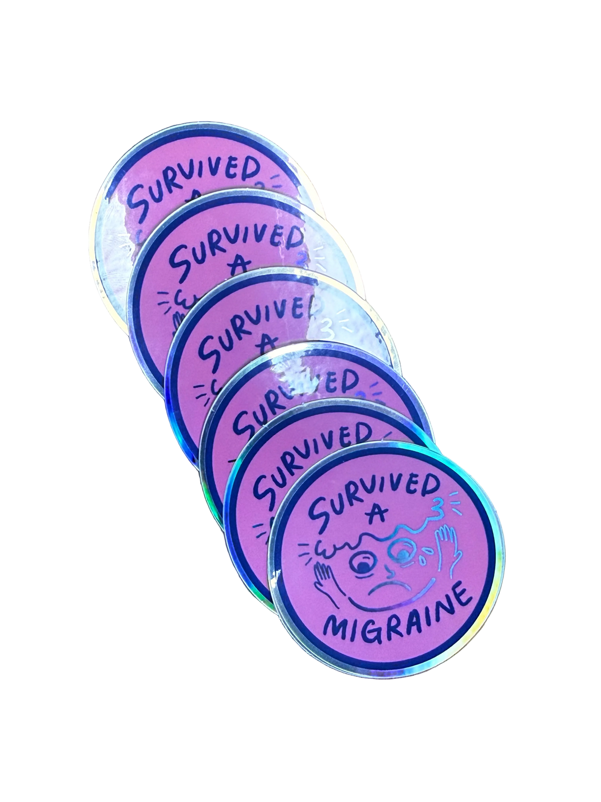Five round holographic stickers fanned out on a brown wood background. Each sticker is pink and purple with the text 'SURVIVED A MIGRAINE' and a simple migraine face illustration.